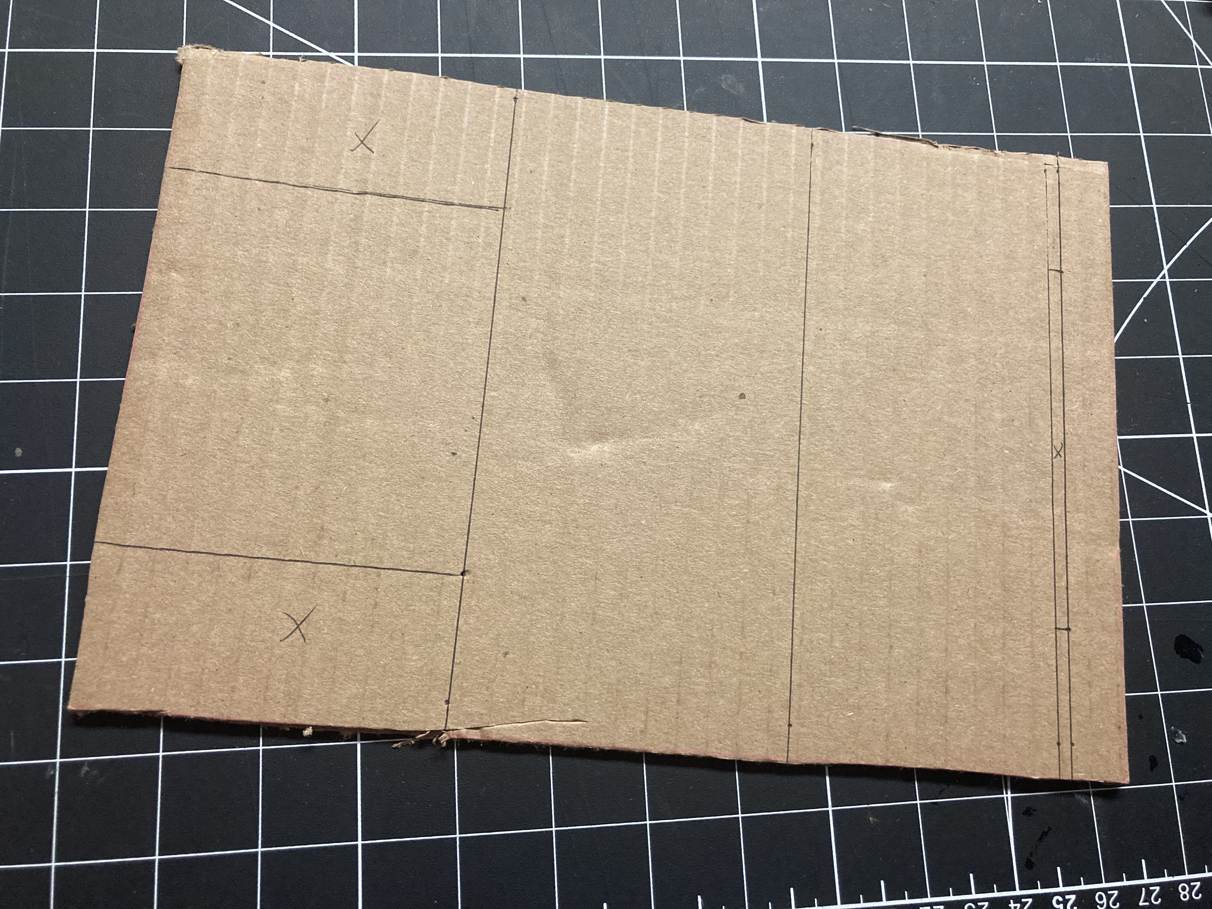 Following the tutorial's instructions, we cut out cardboard pieces of identical dimensions and marked the edges for cutting or folding (to avoid trimming sections that needed to remain intact, areas requiring removal were marked with crosses).